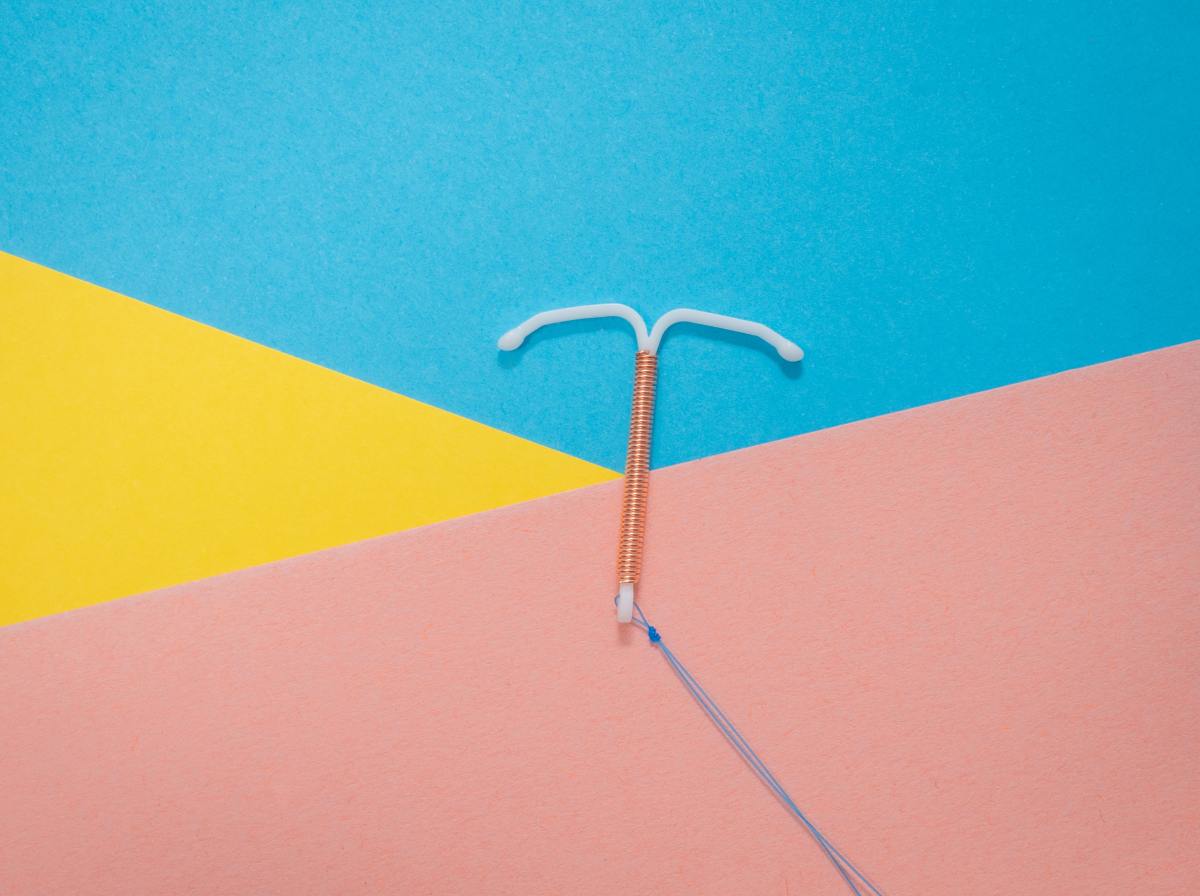 Image shows an IUD on a background of Blue Pink and Yellow