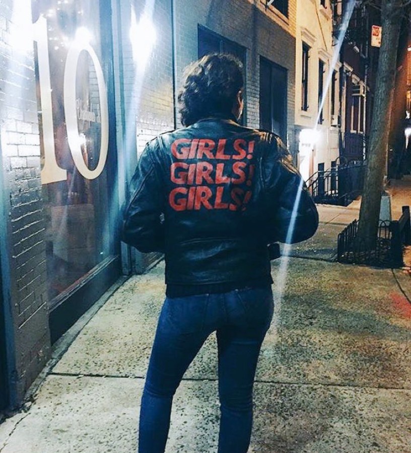 Kayla from behind in a leather jacket that reads GIRLS! GIRLS! GIRLS!
