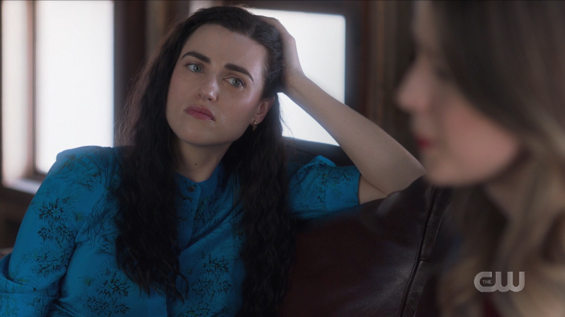 Lena leans on her elbow on the couch
