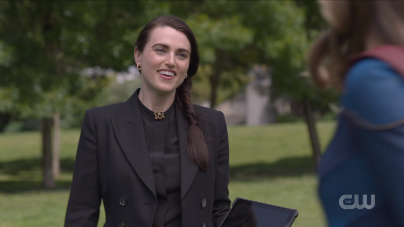 Lena smiles at Supergirl in a black blazer with a beautiful side braid