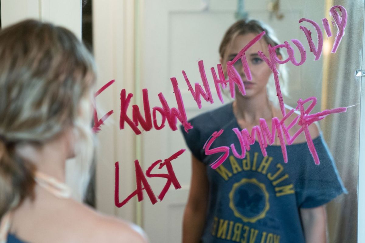 Allison stands in front of a mirror that says I KNOW WHAT YOU DID LAST SUMMER in pink lipstick