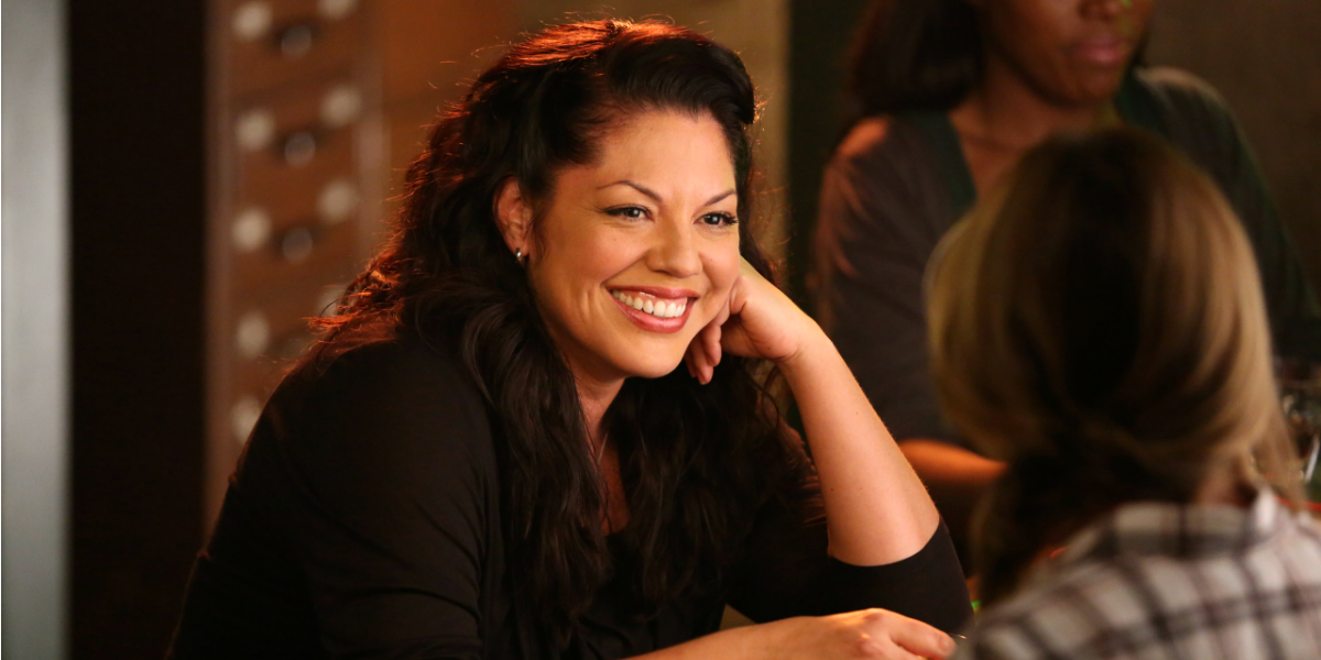 Image Shows a photo of Callie Torres, smiling in a bar wearing a black shirt.