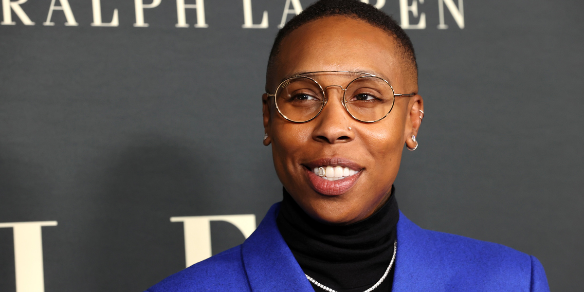 Lena Waithe in a blue suit and glasses, with a gold grill in her mouth