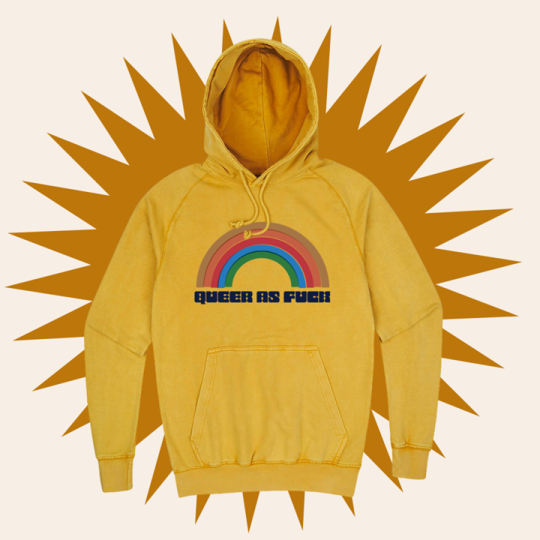 Our Queer as Fuck Hoodie on a beige and mustard background