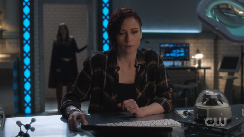 Alex looks worried, Supergirl's silhouette is in the door behind her