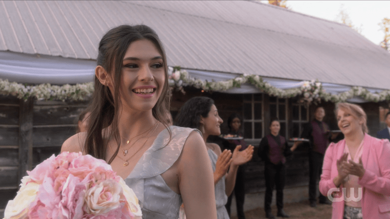 Nia smiles, bouquet in hand