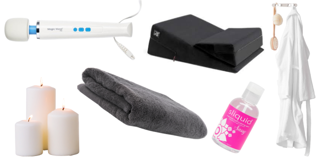 Image of a Magic Wand vibrator, three white candles, a grey towel, a Liberator pillow, a bottle of Sliquid Sassy lube and a white robe and wooden body brush hanging on a hook