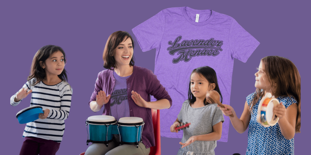 A woman plays the drums surrounded by children with instruments. She's wearing a purple Lavender Menace shirt