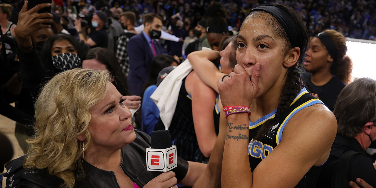 Candace Parker talks to a reporter with her hand over her mouth.