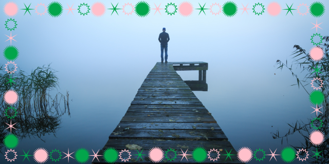 person stands at the end of a dock, looking out into the foggy nothingness of a lake