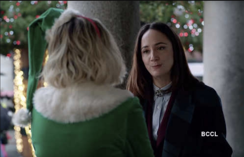 Lesbian in a peacoat talking to a girl in an elf costume