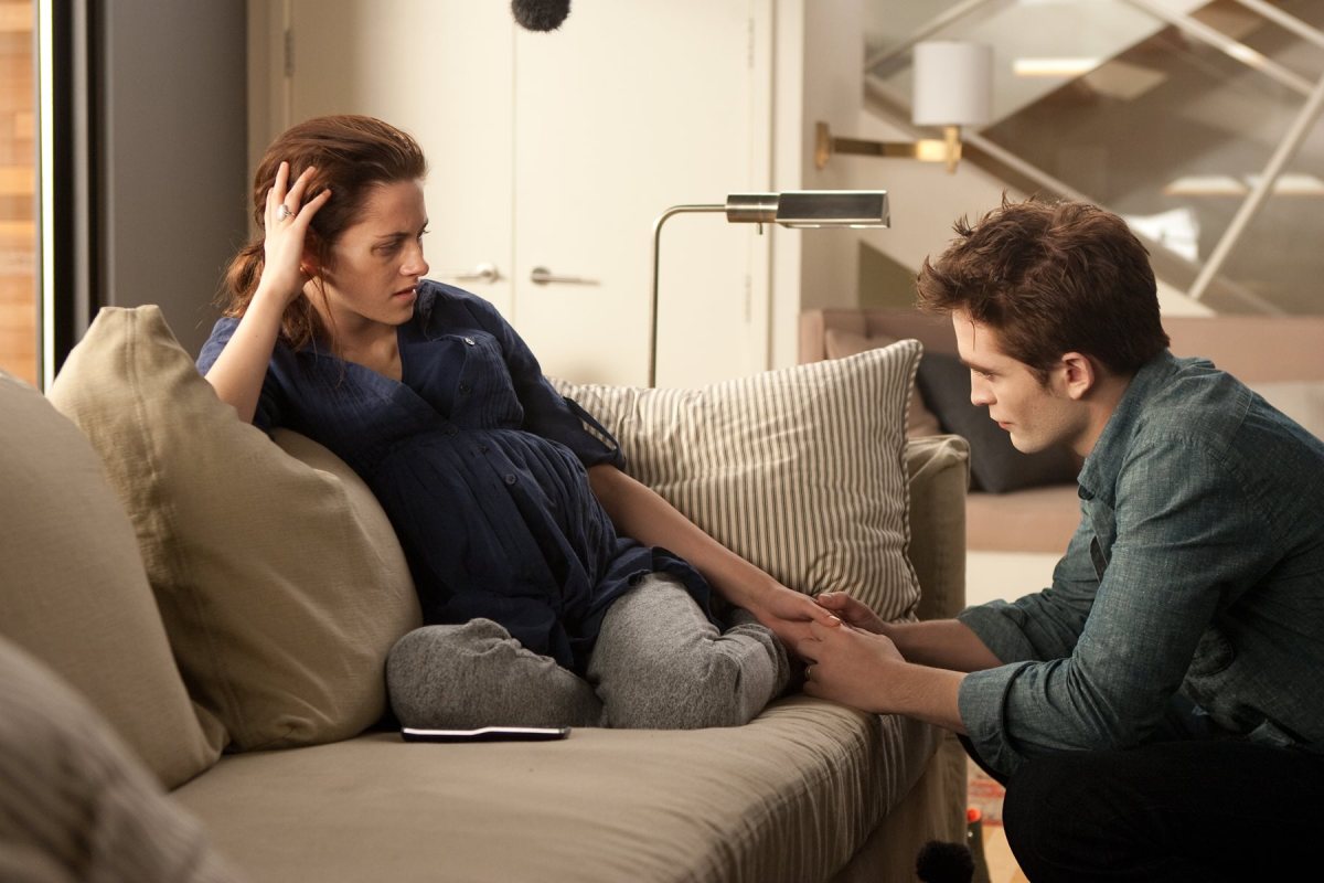 Bella Swan being pregnant and Robert holding her skinny hand in Twilight Breaking Dawn part one