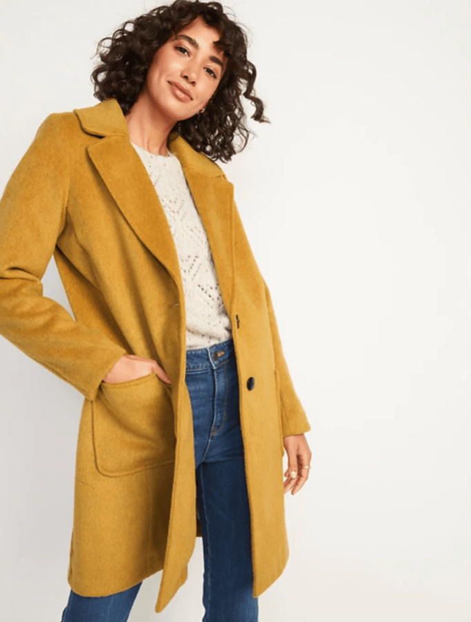A person wearing a mustard colored wool peacoat