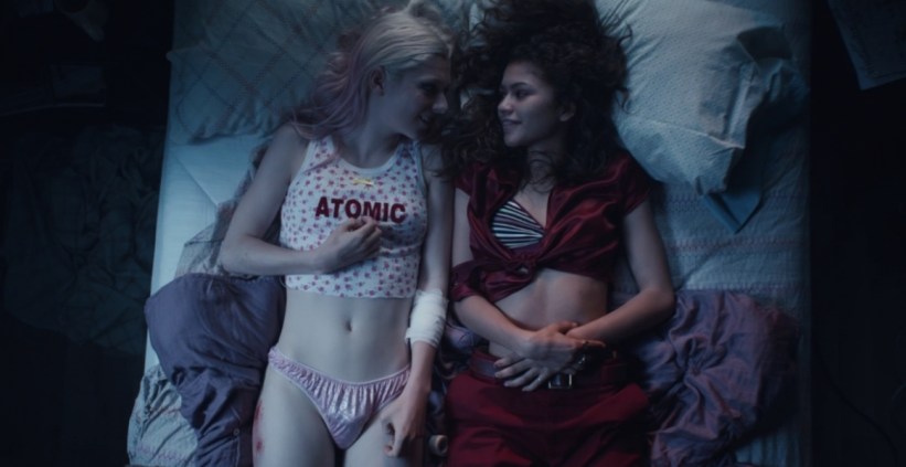 Jules and Rue lay beside one another on a bed.