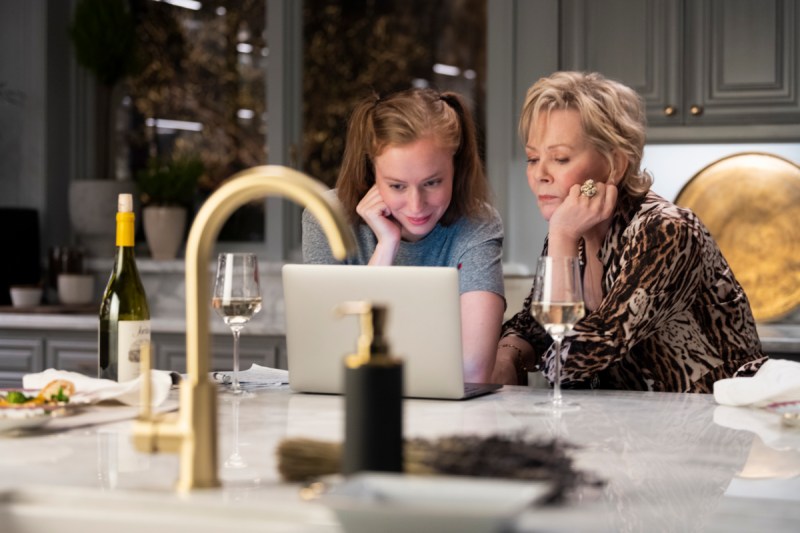 Deborah and Ava look at a computer screen in her kitchen