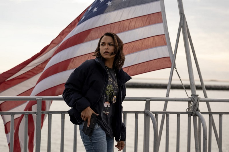 Jackie stands with her hand on her gun, as she searches for Charmaine on the ferry.