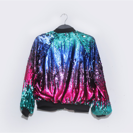 A sequin jacket that is blue, green, pink and purple hangs on a hanger