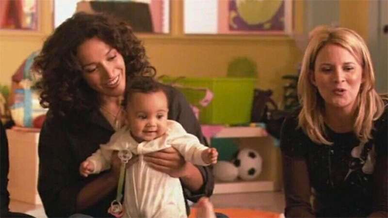 Bette and Tina sit on the floor with baby Angie in the original The L Word