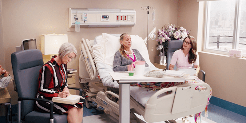 Miranda and Charlotte talk to each other over Carrie's hospital bed while she's asleep