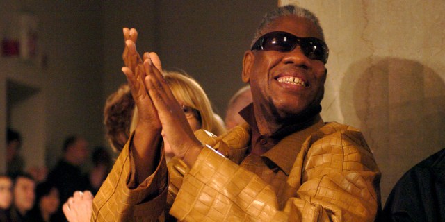 Andre Leon Talley, in gold, laughing and smiling.