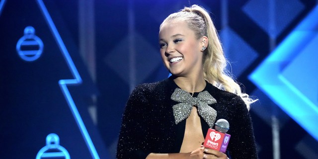 JoJo Siwa speaks onstage during iHeartRadio 102.7 KIIS FM's Jingle Ball 2021 presented by Capital One at The Forum on December 03, 2021 in Los Angeles, California.