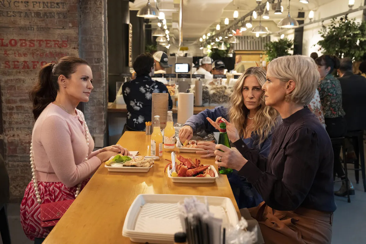 Miranda, Charlotte, and Carrie sit at a table together eating lobster