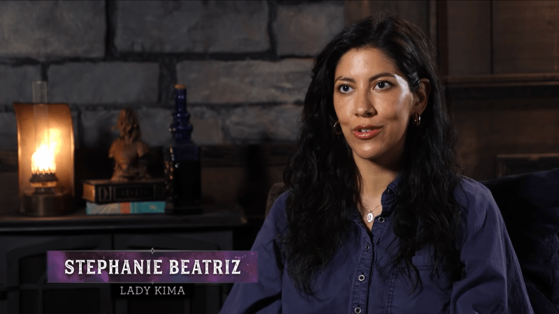 Stephanie Beatriz being interviewed, the text "Stephanie Beatriz as Lady Kima" overlayed