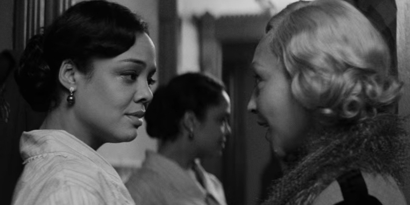 Tessa Thompson looks at Ruth Negga, her reflection in the mirror behind them.