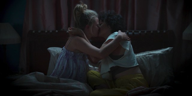 Dory and Portia kiss sitting on a bed in the Search Party season finale