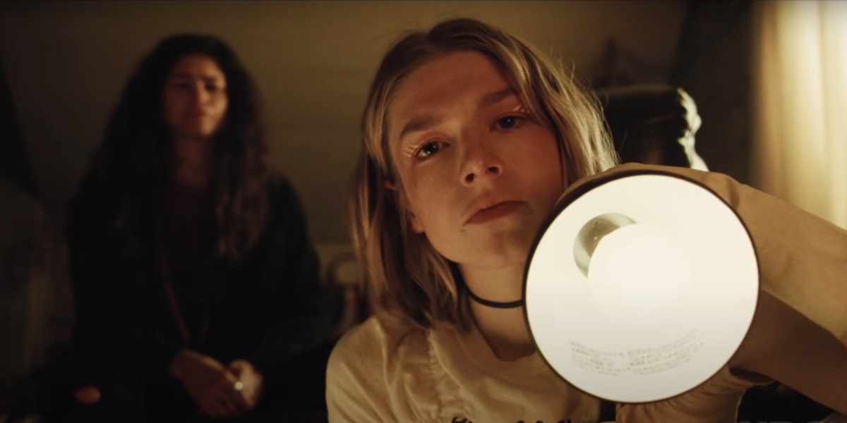 Euphoria recap: Hunter Schafer frowns as she points a lamp toward the camera. Zendaya sits behind her out of focus.