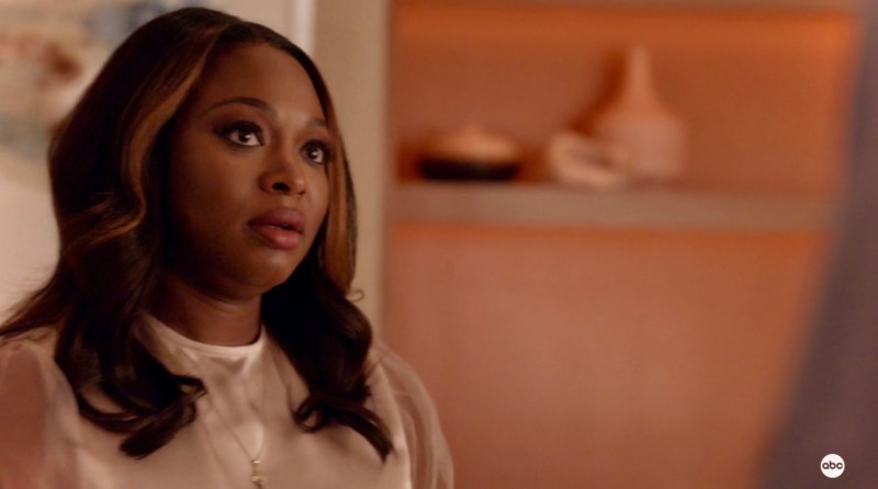 Naturi Naughton in gold and blush shades stares up at the camera with her mouth parted