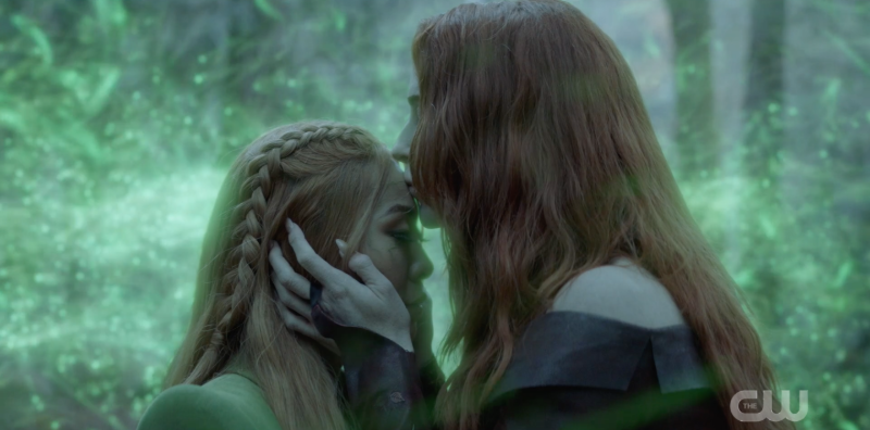 Pam embracing Mary and kissing her on the forehead as green spores surround them