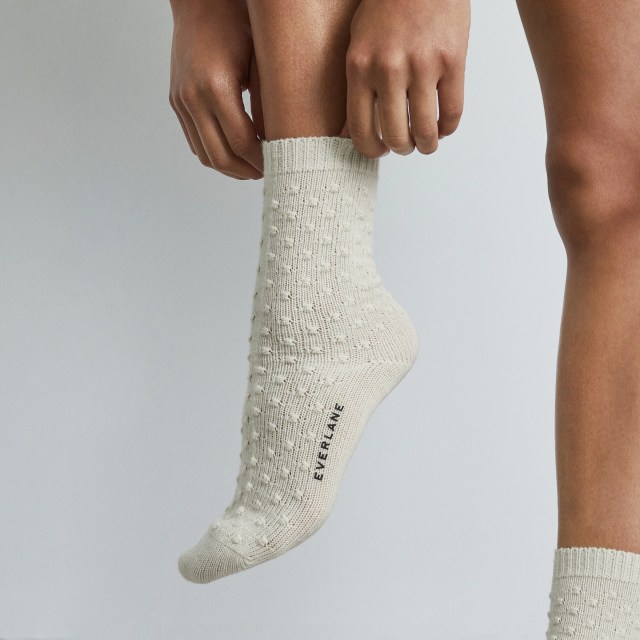 A pair of white socks with pom poms all over