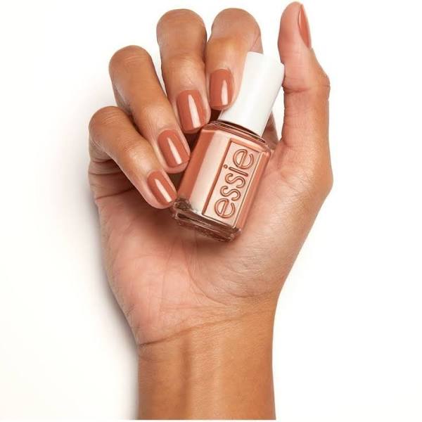 Brown hand holding matching nail polish from Essie
