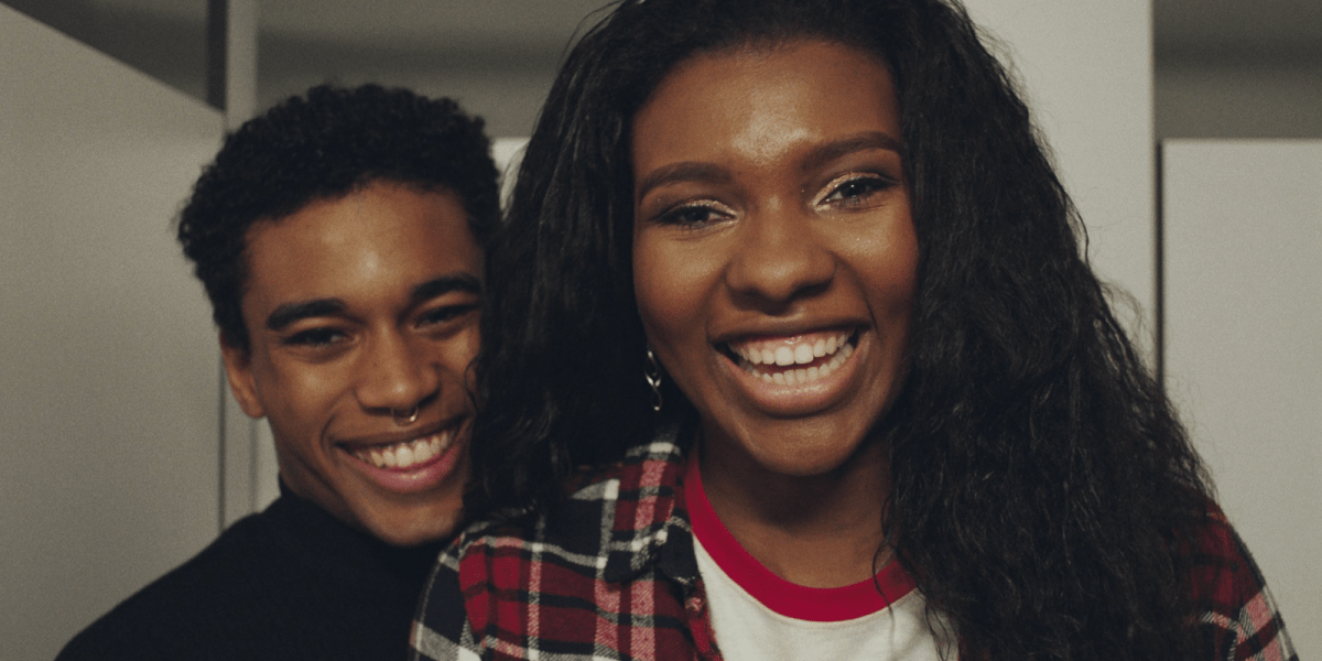 2 Black people smile happily and beautifully while looking in the mirror.