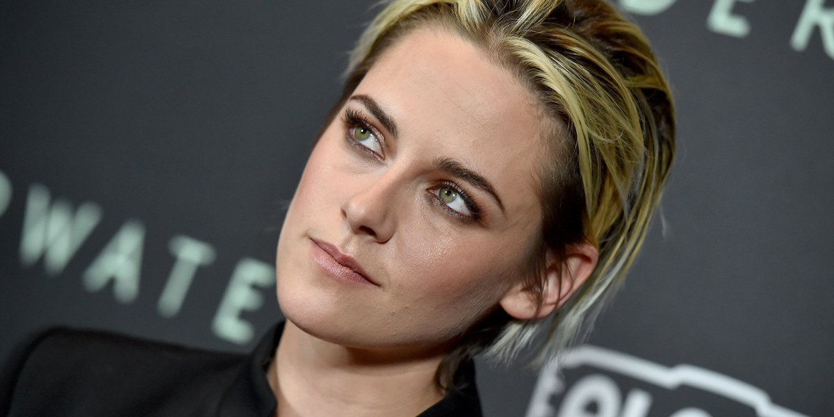 Kristen Stewart looks off to the left of camera with a contemplative look on her face and blond highlights in her short hair, gelled and styled off her face