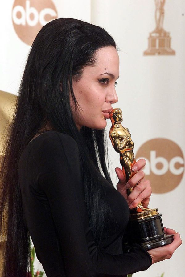 Actress Angelina Jolie kisses her Oscar at the Aca
