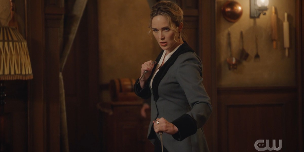 Sara in her petticoat gets into a fighting stance with two knives