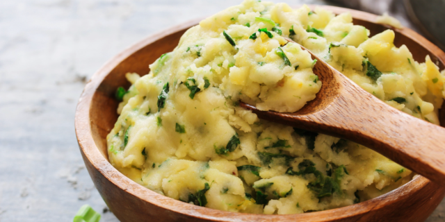Colcannon (chunky potatoes with leek, kale and butter) in a wooden bowl