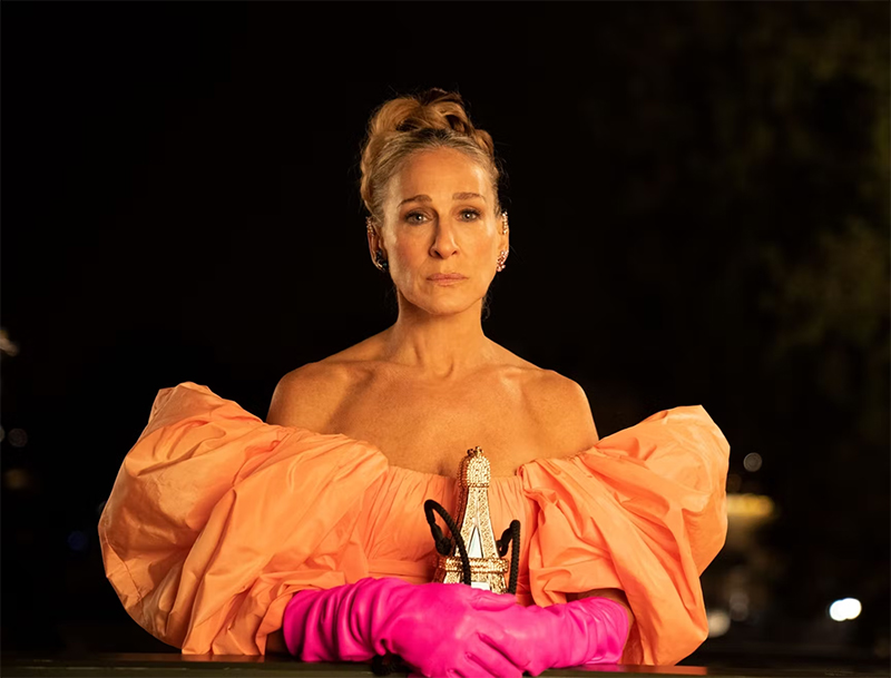 Carrie in an orange dress with pink gloves