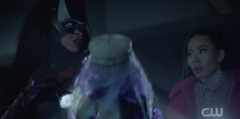 Ryan dressed as Batwoman, with Mary, as they both stare at a creepy doll
