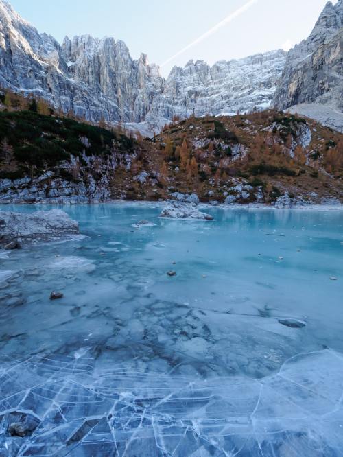an icy blue lake set against mountains