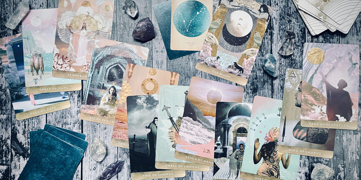 a group of 12 cards from the moonchild tarot, photographed far away from above, against a woodgrain table