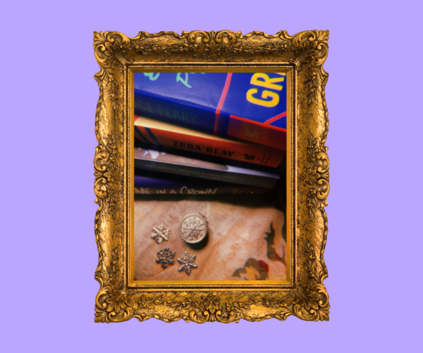 A photo of Shelli's metal snowflakes on her table near some books. The snowflakes are almost coin-sized.