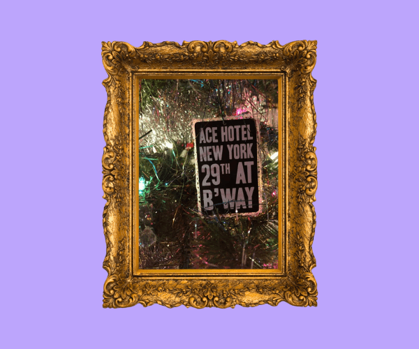 An ace hotel christmas ornament on a christmas tree. It reads Ace Hotel New York 29th at B'Way. The ornament photo is within a golden frame.