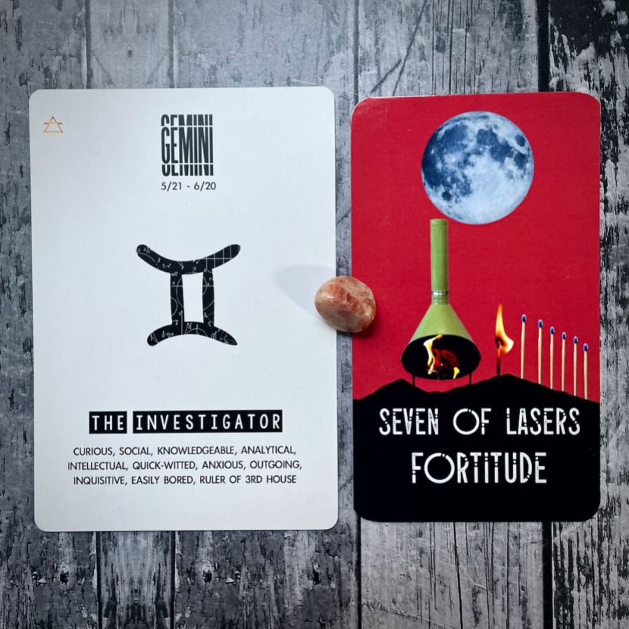 Seven of Lasers Fortitude is a red card with a collage of a full moon and a bonfire, the next card says Gemini is the Investigator