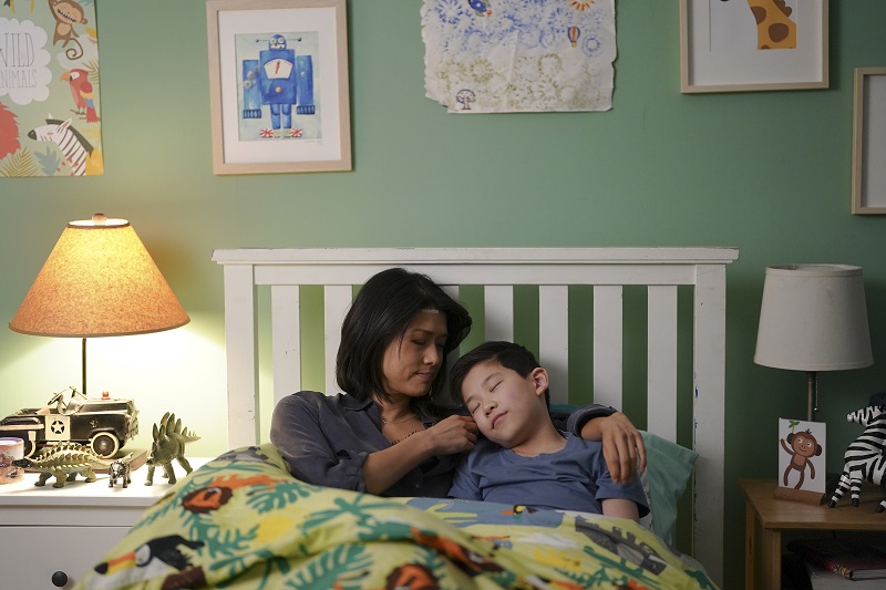 Katherine and Theo cuddle in his twin bed as he tries to fall asleep.