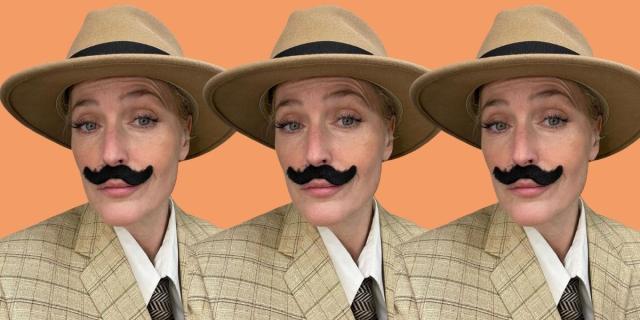 Gillian Anderson has a fake, thick black mustache and a beige fedora hat and a beige checkered suit. She's repeated three times in front of a bright orange background.