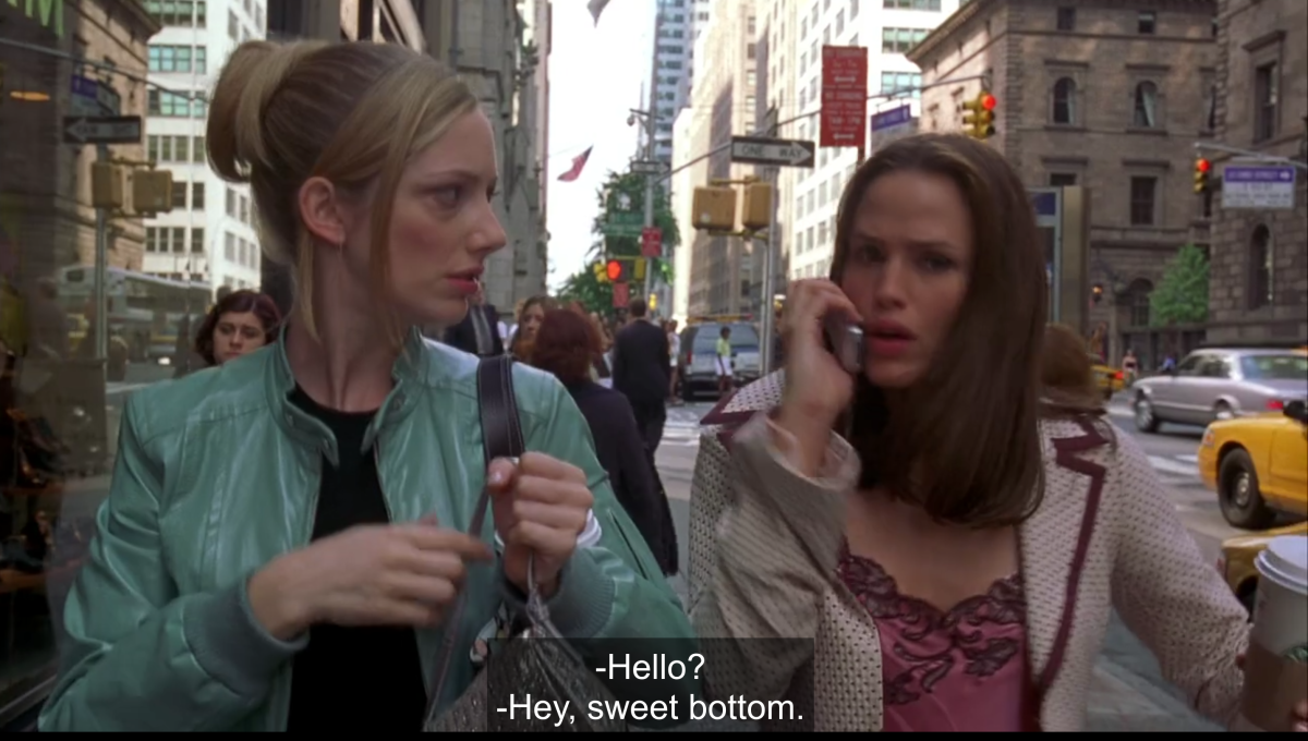 Lucy and Jenna are walking on a New York sidewalk, and Jenna is answering her phone to someone saying "Hey, sweet bottom" on the other end of the line.