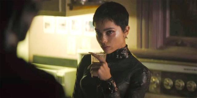 Zoe Kravitz as Catwoman, drinking from a glass in an all-black, all-leather suit